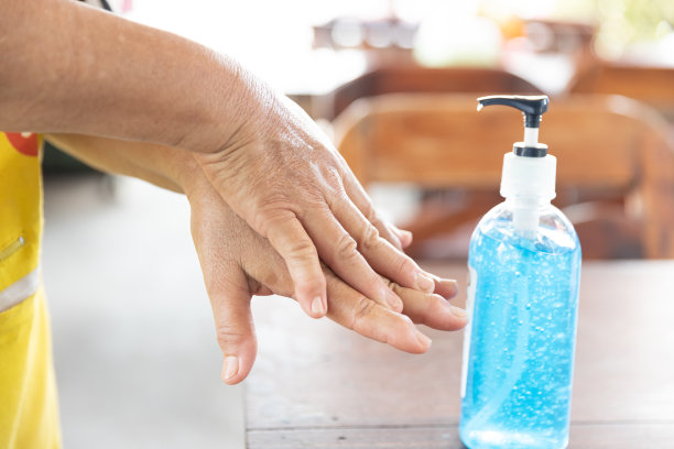 在餐馆背景下，妇女将消毒洗手液倒在手上以预防疾病爆发。保健、个人卫生和保护的大流行和概念。图片下载