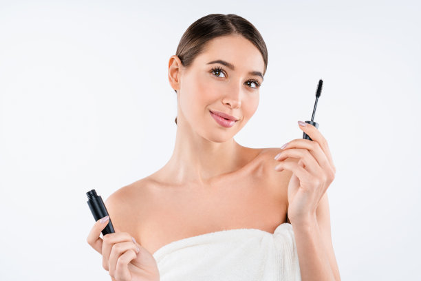 做梦的白人女人与睫毛膏为睫毛刷孤立在白色的背景图片下载