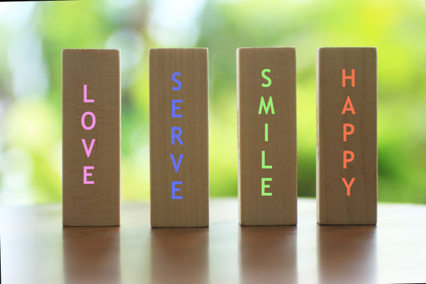 爱。服务。微笑。快乐。正面的单字木块垂直构图。图片下载