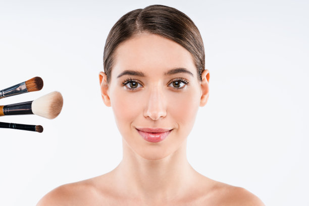 特写美丽的年轻女子与化妆刷隔离在白色的背景图片下载