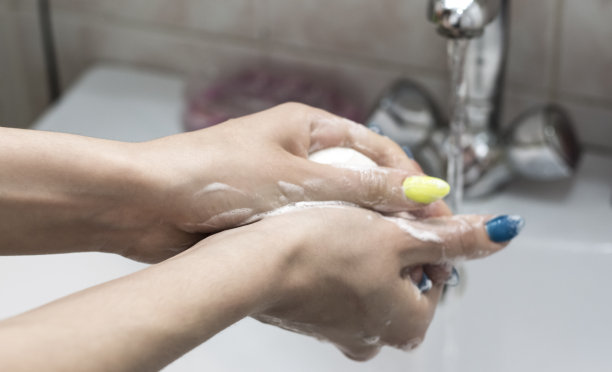 在流动的水中用肥皂洗手图片下载