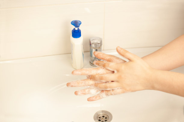 在隔离期间，女孩在街道上洗手。预防冠状病毒大流行，用温水和抗菌肥皂彻底洗手。世界流行的概念。图片下载