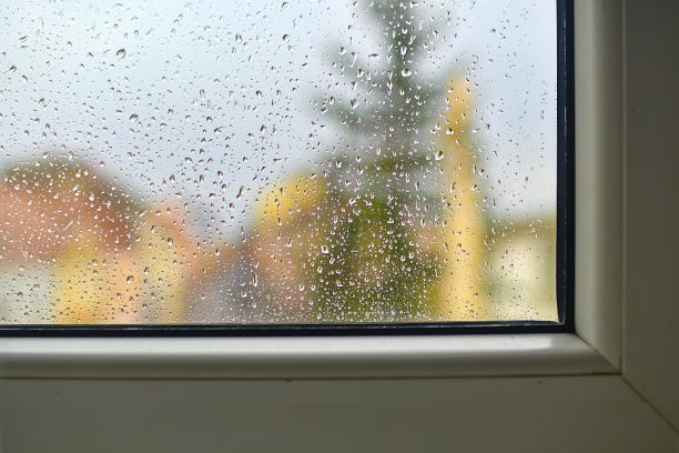 透过窗户看不清雨天的景色。雨滴落在玻璃窗上。图片下载