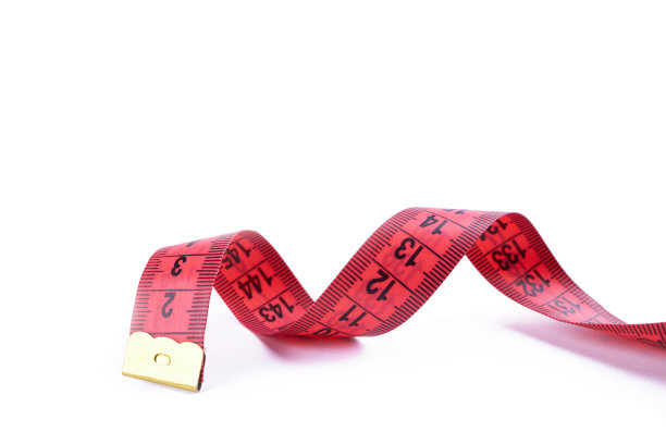 苗条的概念。白色背景上孤立的红色卷尺。健康饮食的概念。图片下载