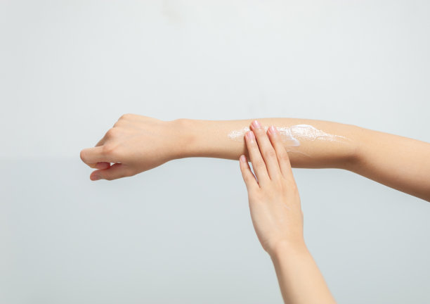 女性在手上涂抹保湿霜，美容理念。素材图片