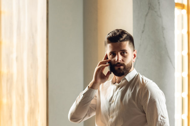 在咖啡馆室内的魅力成人胡须男子，具有复制空间的生活方式概念照片，商人图片，他正在用手机通话图片下载