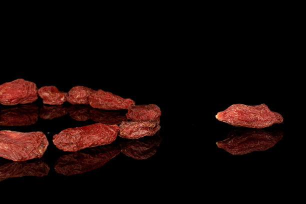 红色干燥的枸杞孤立在黑色玻璃上图片下载