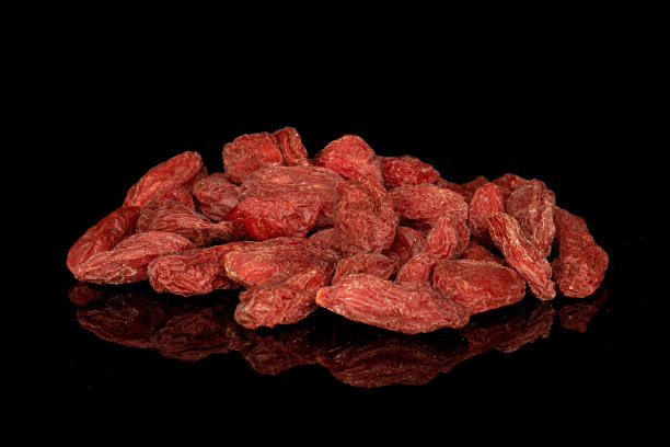 红色干燥的枸杞孤立在黑色玻璃上图片下载