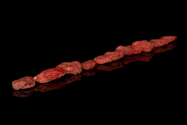 红色干燥的枸杞孤立在黑色玻璃上图片下载