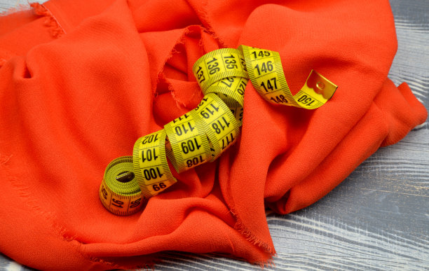 卷尺在红色织物背景上图片下载