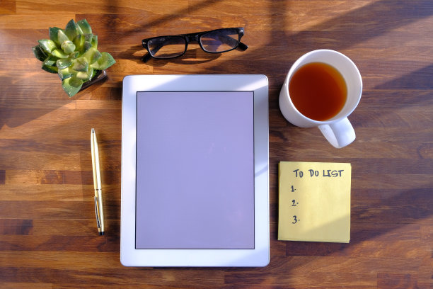 俯视图的数字平板电脑，茶和记事本在木桌上图片下载