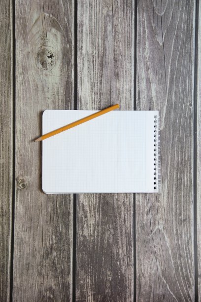 记事本与空白白纸在方格纸和简单的石墨铅笔躺在木板的背景图片下载