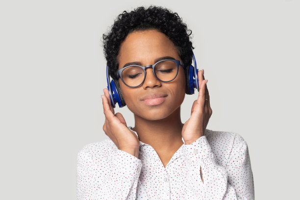 戴着耳机享受音乐的放松的非裔美国女子头像照片图片下载