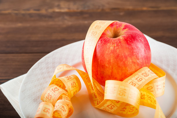 健康的生活方式的概念。红苹果和厘米特写和复制空间。水果的饮食概念图片下载