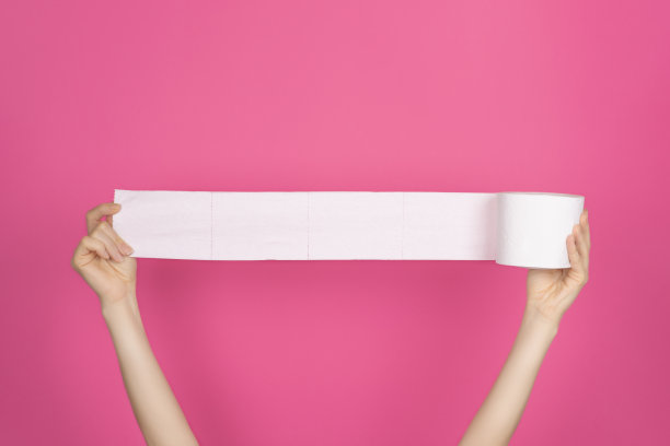 柔软，白色卫生纸卷在明亮的粉红色背景。卫生的概念。图片下载