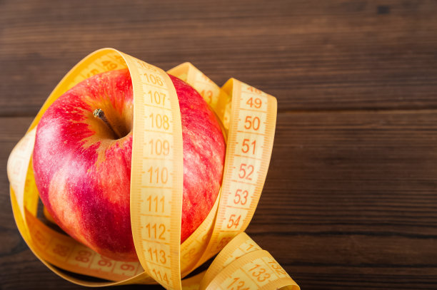 健康的生活方式的概念。红苹果和厘米特写和复制空间。水果的饮食概念图片下载