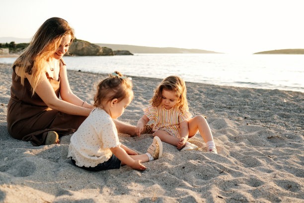 快乐的母亲和女儿们在海边玩耍图片下载