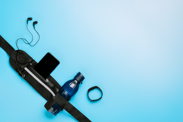 跑步带，健身智能手环，水瓶和耳机在时尚的蓝色背景，文字空间图片下载