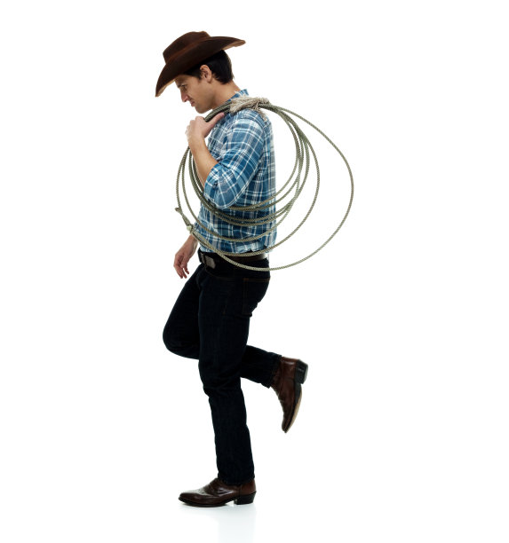 白人男性牛仔戴着牛仔帽，手持套索，用绳子站在白色背景前图片下载