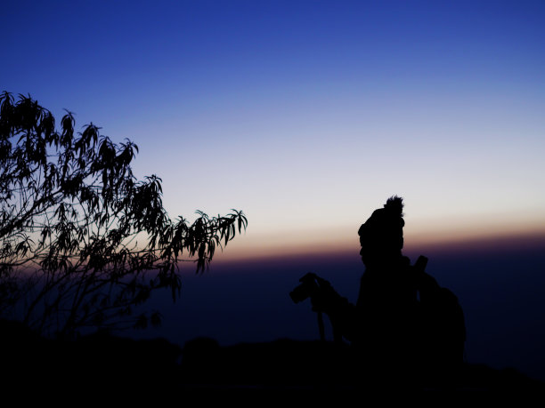 戏剧性天空下的女摄影师剪影图片下载