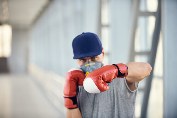 戴着防护面罩和拳击手套的男人与病毒作斗争，新型冠状病毒概念照片图片下载