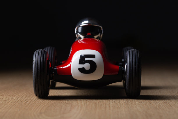 木制表面上的老式红色玩具赛车图片下载