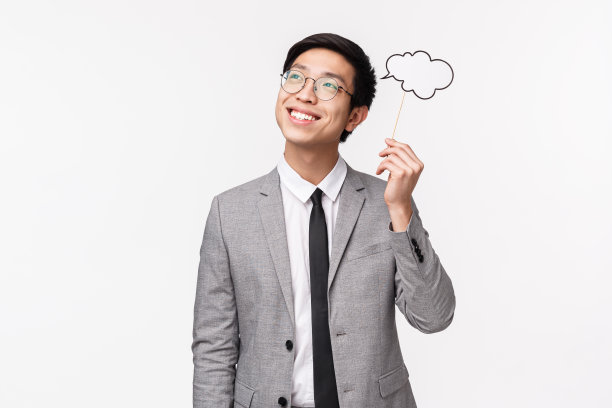 灵感、生活方式与商业理念：快乐而梦幻的亚洲职场男士，身穿灰色西装，戴眼镜，手持评论云朵，若有所思图片下载