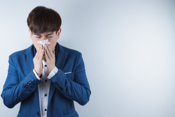 因新冠病毒和PM2.5而擤鼻涕的商人：新冠病毒与PM2.5空气污染概念图片下载