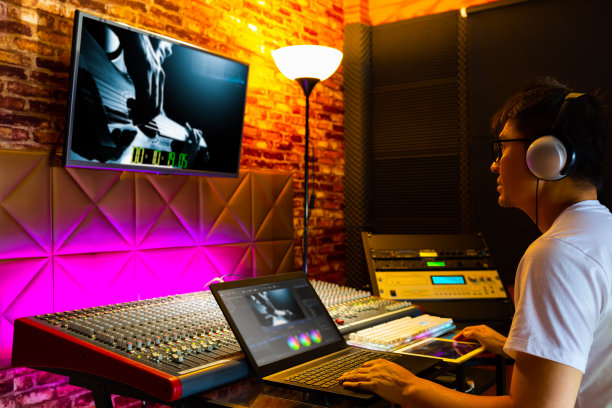 亚洲男性导演、剪辑师、制片人在后期制作工作室的电脑上编辑素材和电影调色图片下载