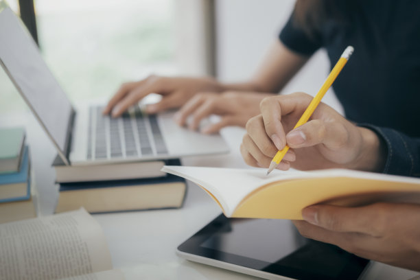 年轻学生在校园里帮助朋友赶上学习进度图片下载