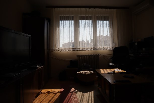 黑暗的客厅，窗户被阳光照亮，背光室内拍摄一个昏暗的背光房间。阳光照进黑暗的房间，把窗户照得背光图片下载