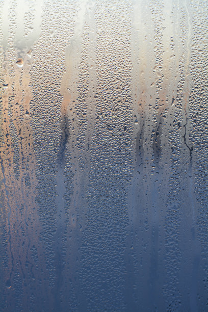 玻璃上的纹理落在黎明的太阳背景上。明亮的蓝橙色图片下载