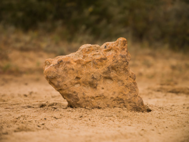 美丽的石头在模糊的背景上的沙子图片下载