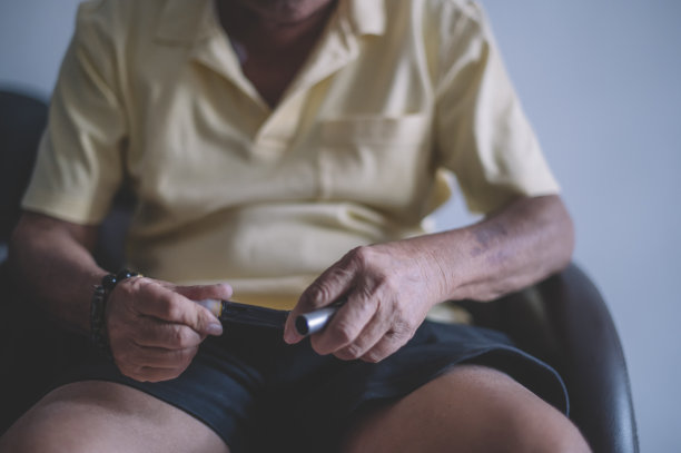 一名亚裔华人老人每天将注射器胰岛素注射到腹部图片下载