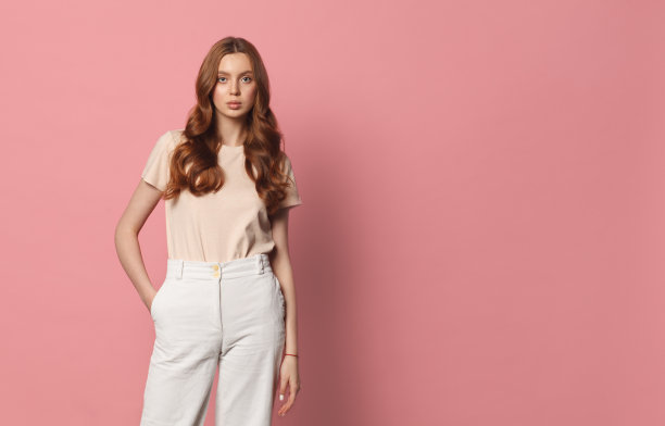 粉红色背景的年轻女性休闲装图片下载