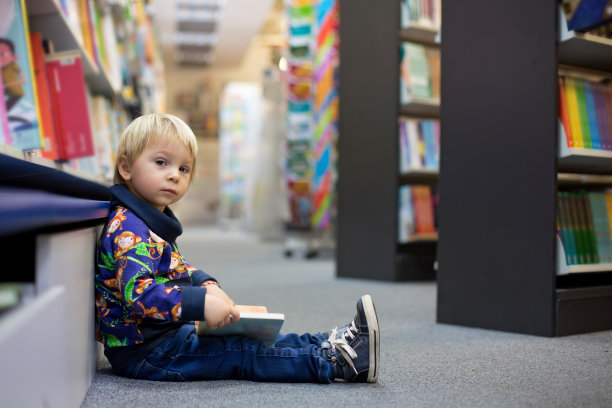可爱的小男孩，坐在书店里图片下载