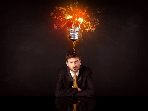 在创意灯泡下工作的商人图片下载