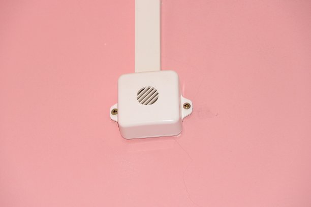 粉红色的墙上挂着消防系统的白色喇叭。消防安全概念图片下载