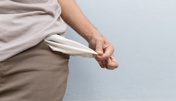 穿着空口袋牛仔裤的男人。没有金钱的概念与软焦点和在背景过光图片下载