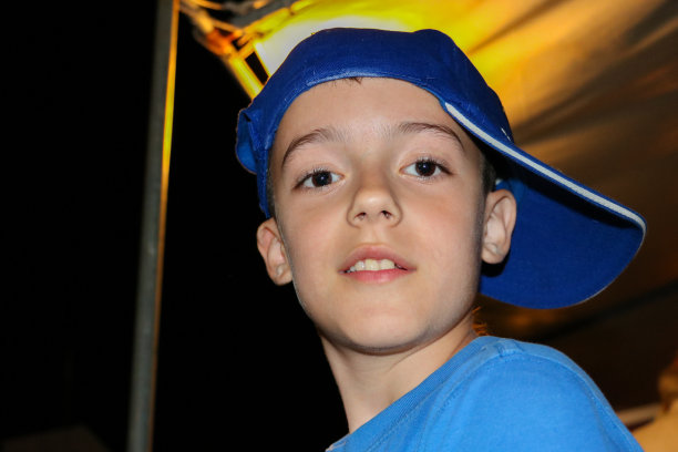 一个孩子的肖像看起来在一个黑暗的背景相机。图片下载