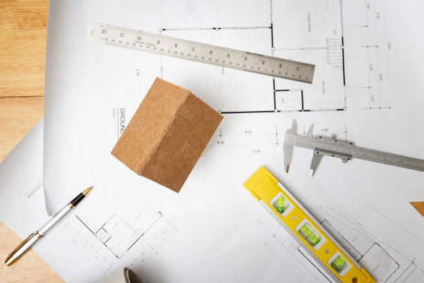 商业，建筑，建筑和建造概念-俯视图建筑师房屋模型与测量工具和蓝图在建筑师的办公桌上图片下载