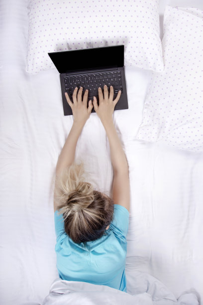 在床上工作的女商人图片下载