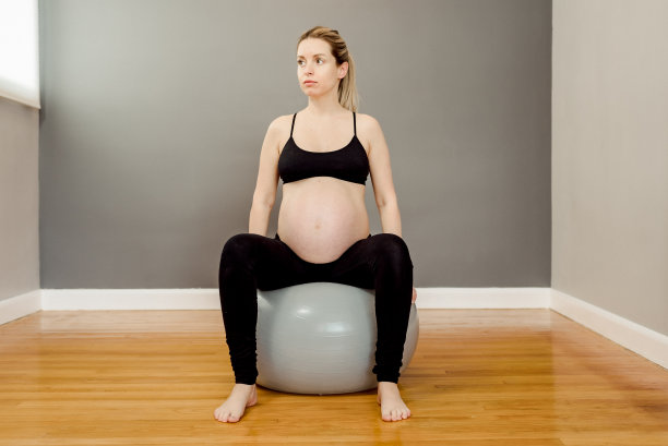 坐在瑜伽球上的孕妇图片下载