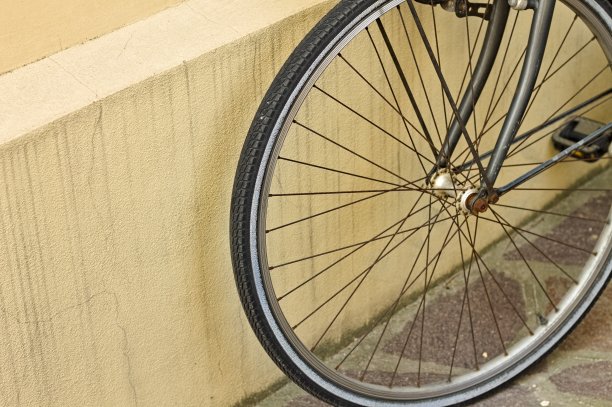 自行车轮子靠在一辆破旧自行车的墙上(Pesaro，意大利，欧洲)图片下载