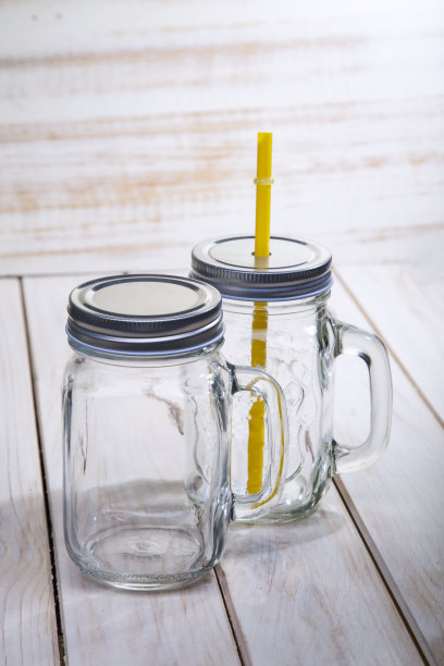 空玻璃玻璃瓶与处理和饮用稻草隔离在木白色背景图片下载