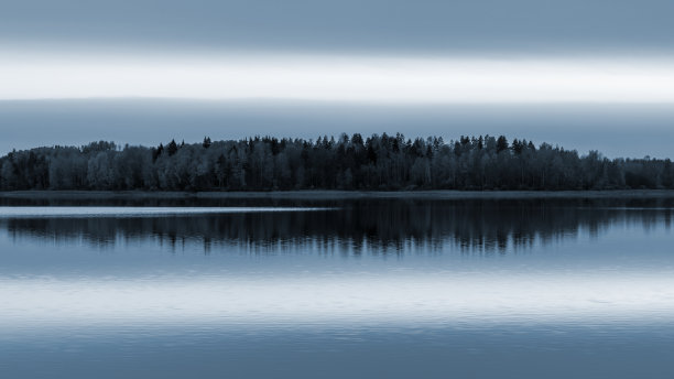 宁静的风景。夕阳映在湖面上，水面平静，倒影对称图片下载