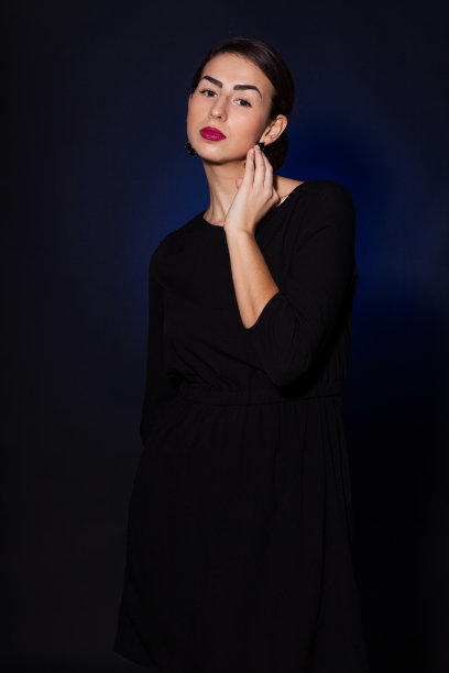 年轻的俄罗斯女孩穿着黑色裙子，背景是黑色的图片下载