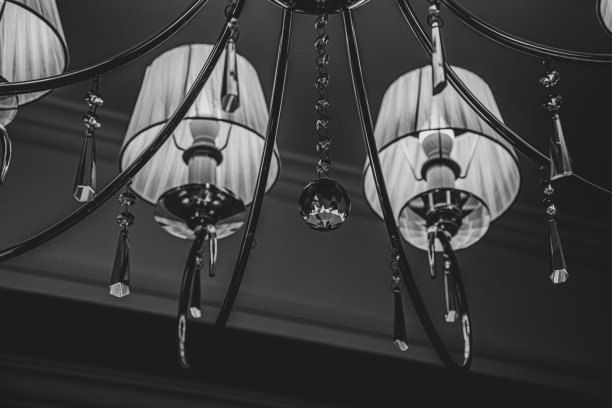 柔和的焦点维多利亚风格的灯的细节。复古吊灯的特写与白色灯罩和闪亮的透明水晶悬挂和珠宝形状的玻璃吊坠。黑白照片。图片下载