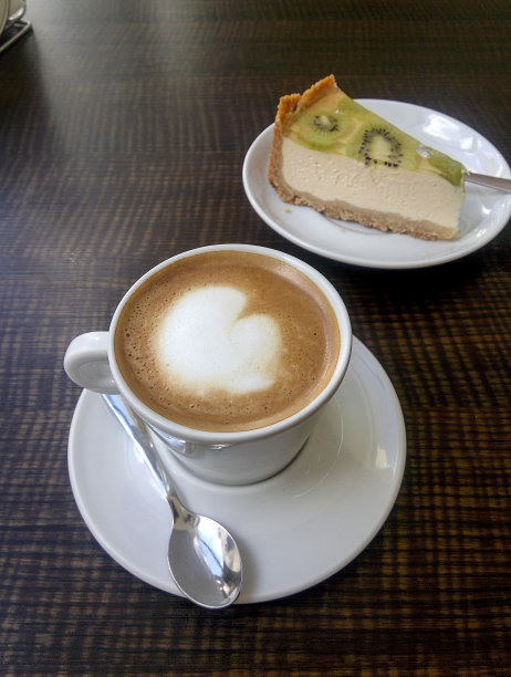 一杯咖啡或卡布奇诺和一块奶酪蛋糕图片下载