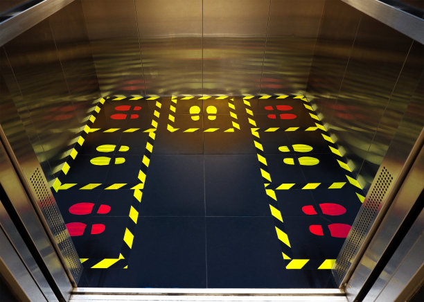 警告标志黄色和黑色条纹的地板背景。电梯安全区域。病毒保护。请站在指定区域内，减少可能接触COVID-19和冠状病毒的风险。图片下载